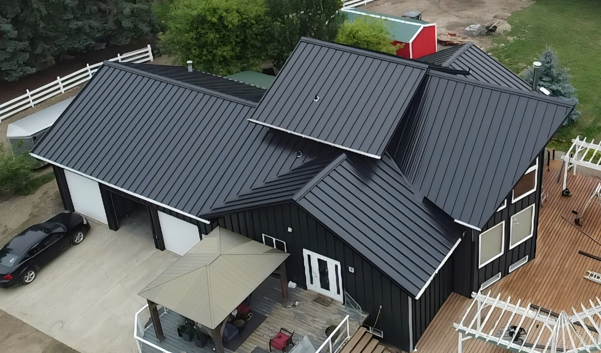 Aerial view of a black standing seam metal roof and board-and-batten steel siding on a Saskatchewan home