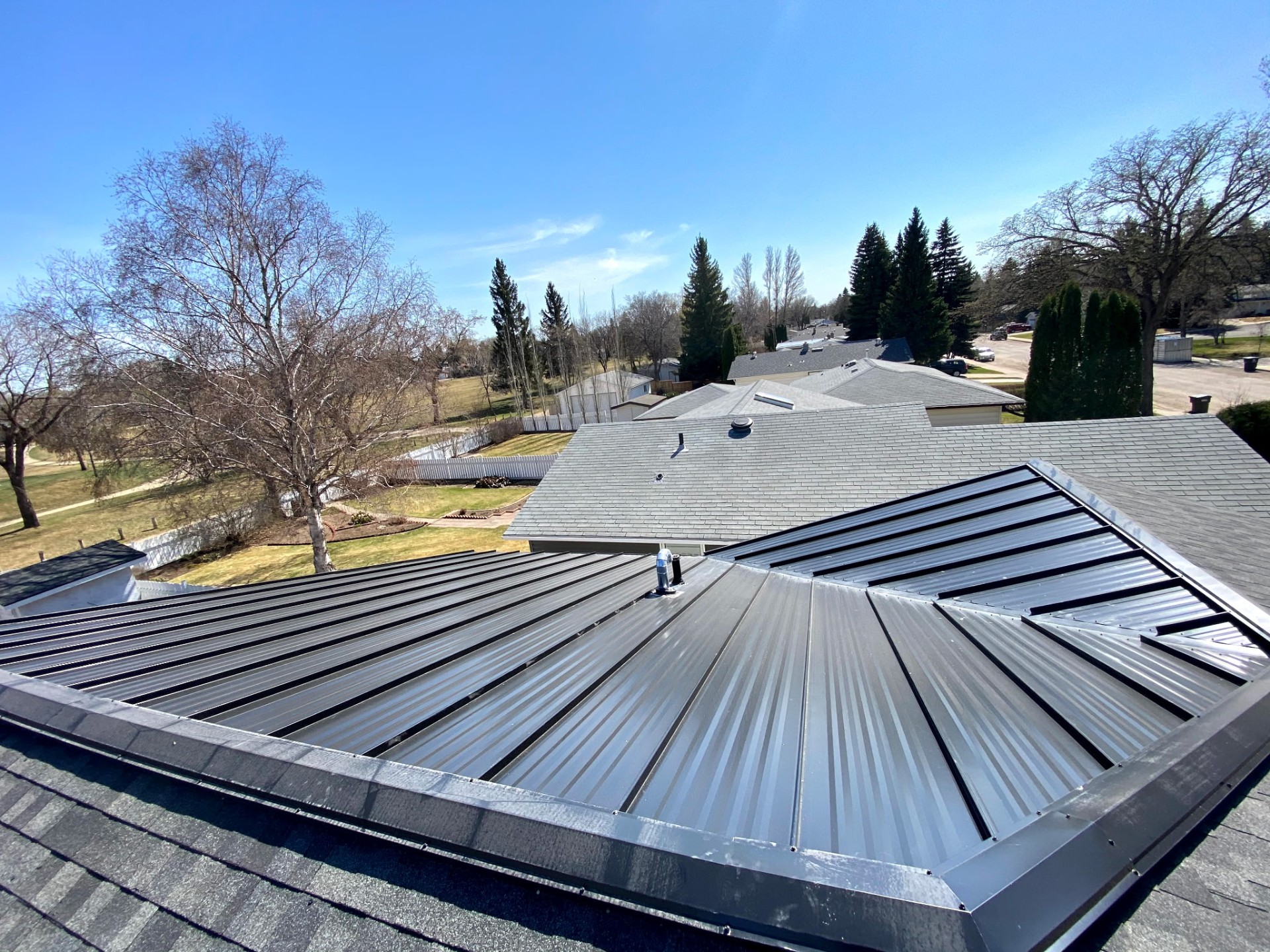 Aerial view of a hybrid roof — standing seam on one section, shingles on the remainder of the house