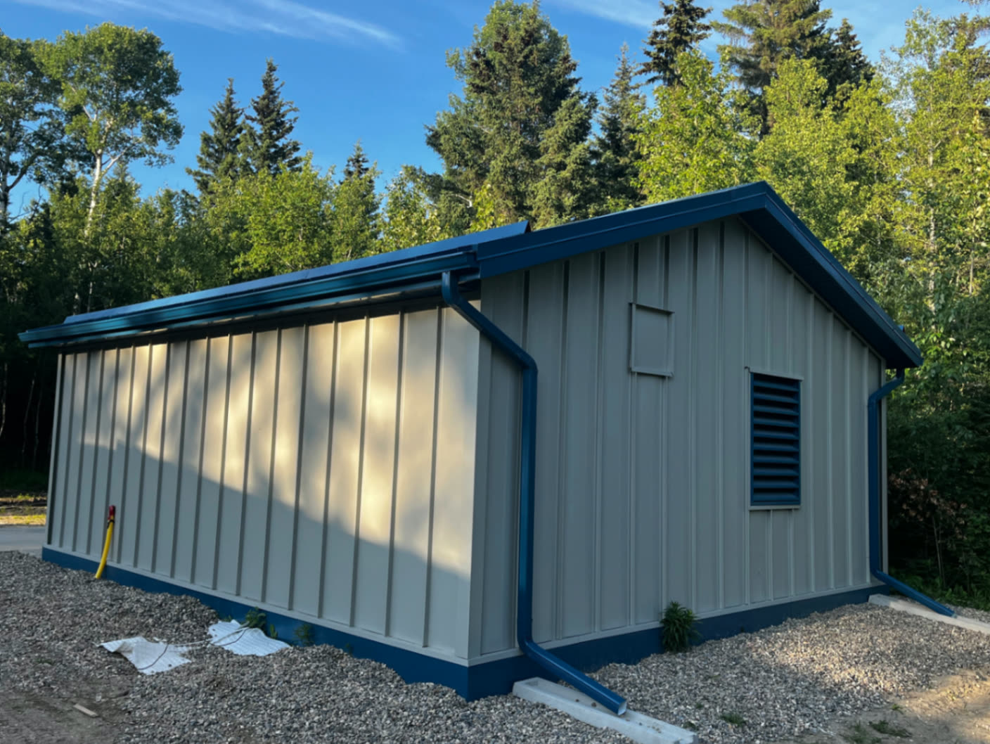 Rear angle — seamless eavestrough and downspout in matching blue.