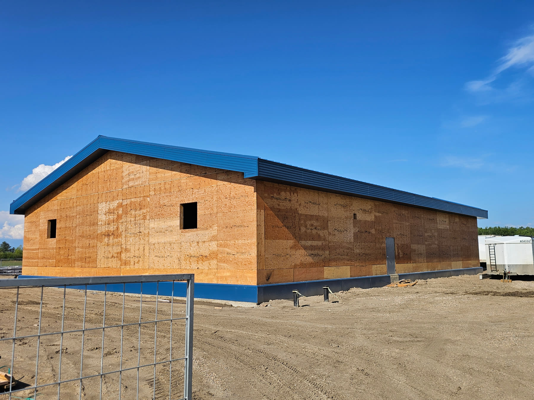 Rear gable view — long roof run with matching blue trim and deep overhangs.
