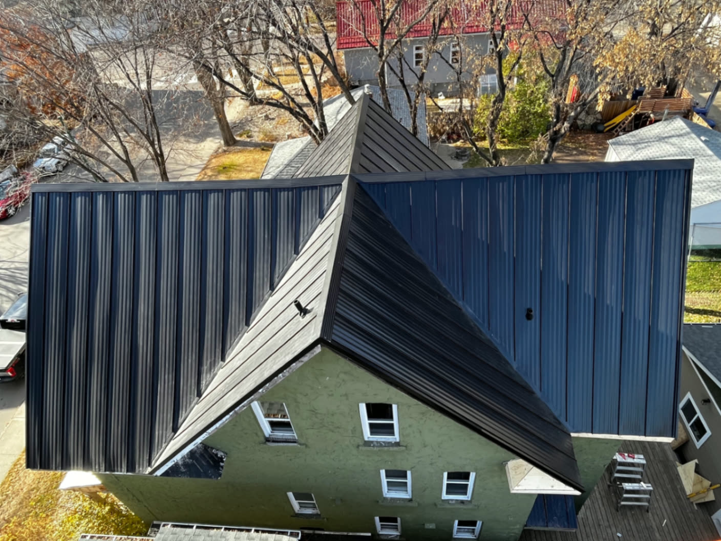 Aerial view — black standing seam metal roof over the multi-gable heritage rooflines.