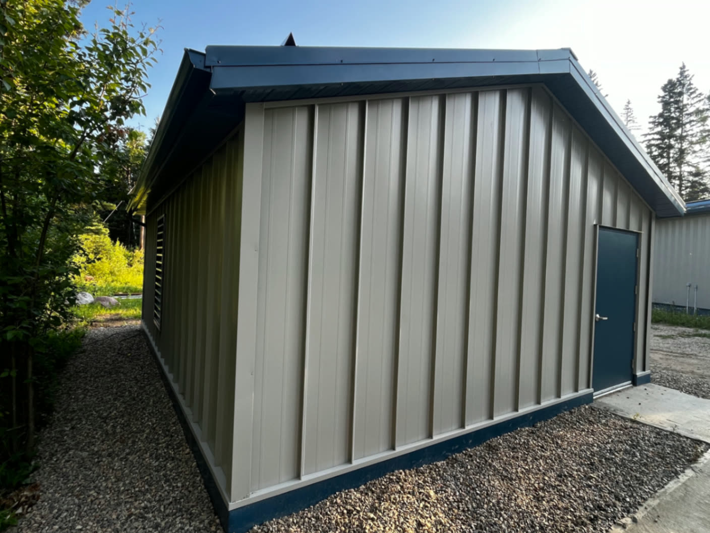 Side elevation — vertical metal siding with colour-matched fascia and trim.