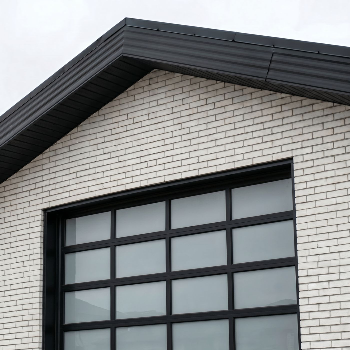Seamless striated black metal fascia installed on a gable roofline